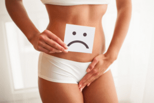 Mulher com desconforto íntimo pesquisando sobre coceira vaginal e saúde ginecológica.
